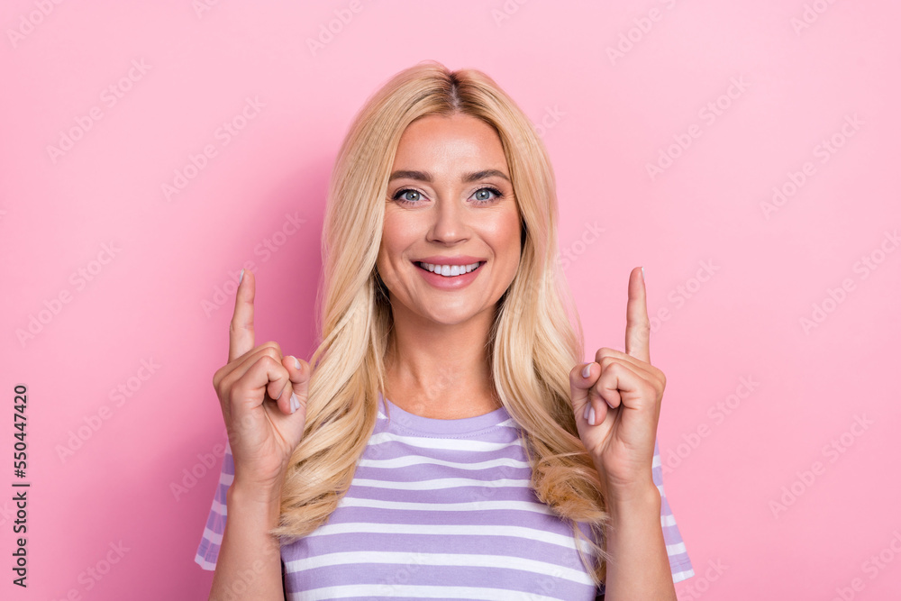 Portrait of young smiling fancy chic directing fingers up empty space new cosmetology brand skincare promo isolated on pink color background Portrait of young smiling fancy chic directing fingers up empty space new cosmetology brand skincare promo isolated on pink color background
