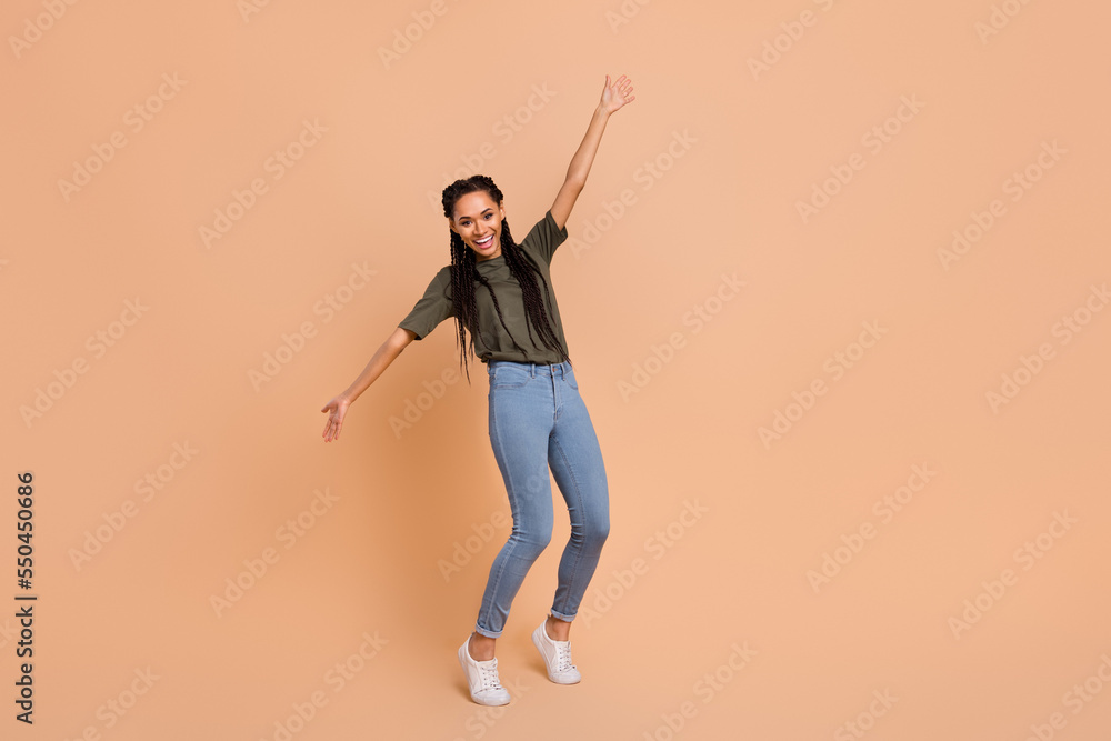 Full size photo of cheerful charming girl dancing chilling good mood isolated on beige color background Full size photo of cheerful charming girl dancing chilling good mood isolated on beige color background