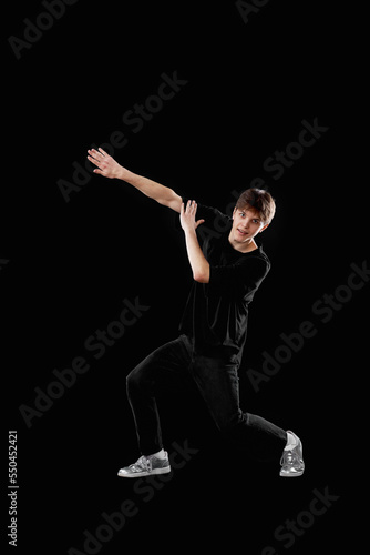 young man in black t-shirt and jeans dancing