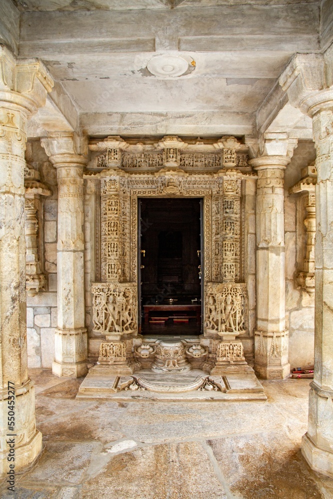 Naklejka premium Statues of people on the walls with columns, ranakpur jain temple, India