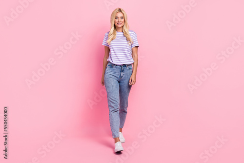 Full body photo of gorgeous satisfied lady have good mood walking isolated on pink color background