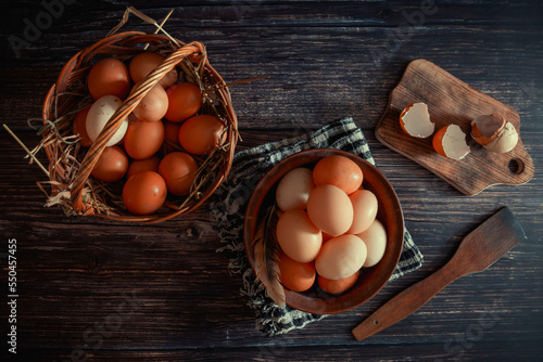 Chicken eggs in a clay plate and a basket on the table