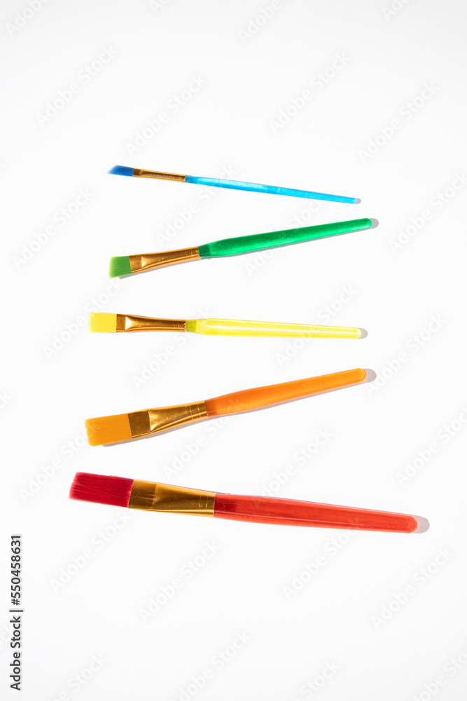 Colored brushes for drawing on a white background. Top view, flat lay