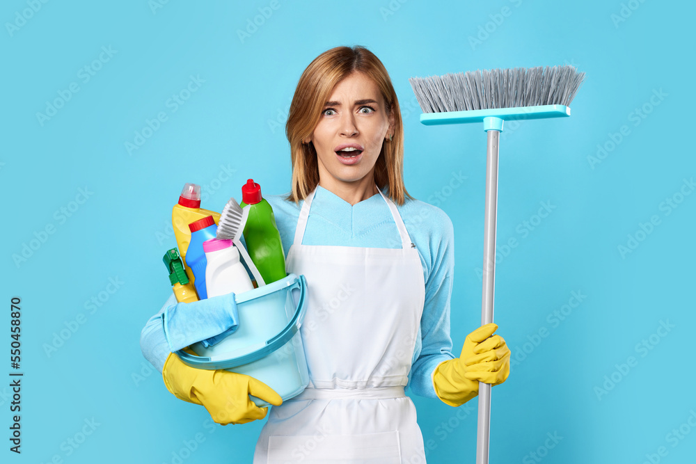 woman in gloves holding bucket of detergents and broom woman in gloves holding bucket of detergents and broom