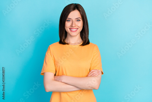 Photo of positive cheerful optimistic lady arm folded good mood beaming smile isolated on blue color background photo