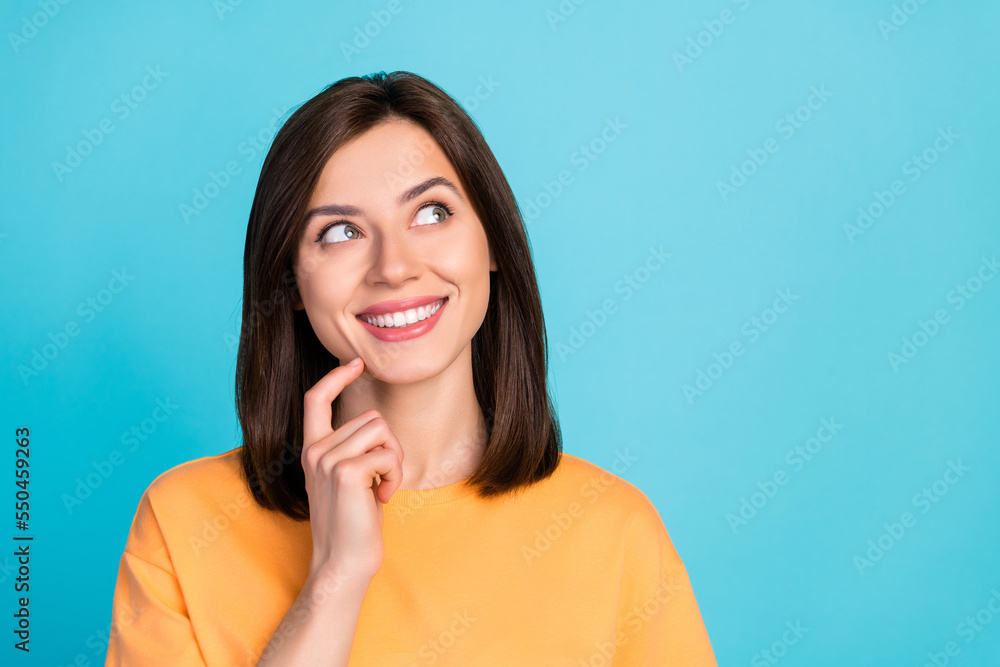 Photo of pleasant thoughtful girl with straight hairdo wear yellow t-shirt look empty space finger chin isolated on blue color background Photo of pleasant thoughtful girl with straight hairdo wear yellow t-shirt look empty space finger chin isolated on blue color background