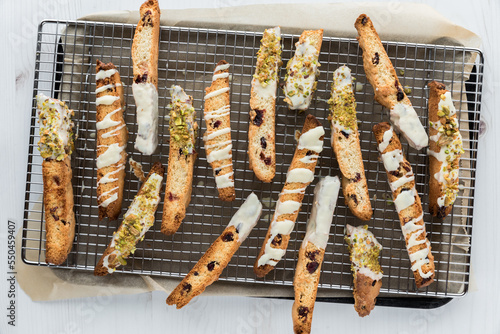 Pieces of homemade cranberry and pistachio biscotti on a cooling rack.