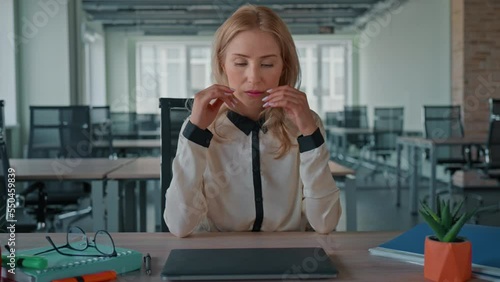 front view exhausted businesswoman turn of computer looking camera suffering from headache sitting at the desk in the office