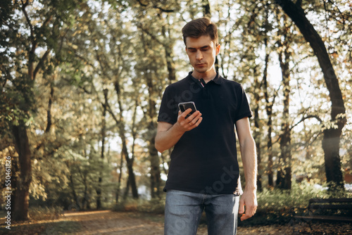 a man on a walk in the park uses a mobile phone