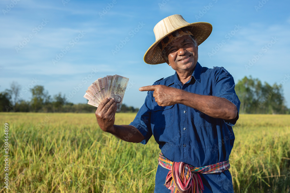 Smiling Elderly Thai Farmer Holding Thai Money Banknote Wearing smiling-elderly-thai-farmer-holding-thai-money-banknote-wearing