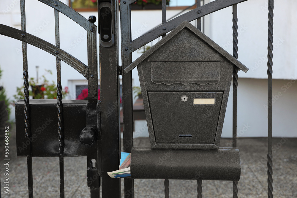 Black metal letter box on fence outdoors