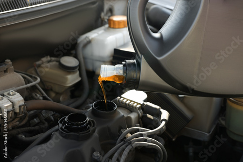 Pouring motor oil into car engine, closeup
