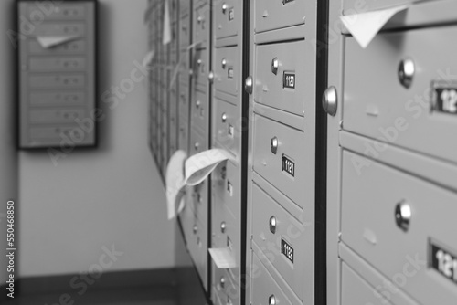 Closed grey metal mailboxes with receipts indoors, closeup. Space for text