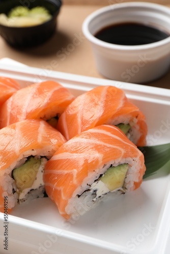 Food delivery. Delicious sushi rolls in plastic container, closeup