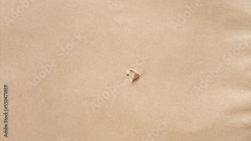 Beige packaging paper unwrapping from the center, unpacking and bursting from the center. Presents and surprises for holidays. Overlay, many layers. Stop motion video, 4k resolution, copy space