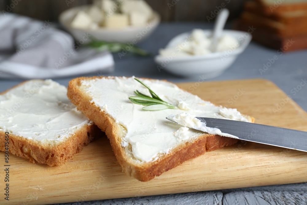 Delicious toasts with tofu cream cheese and rosemary on wooden board, closeup Delicious toasts with tofu cream cheese and rosemary on wooden board, closeup