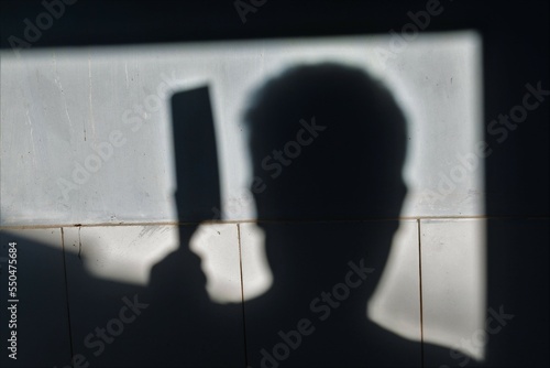 Silhouette of sad male head holding knife. concept of killing