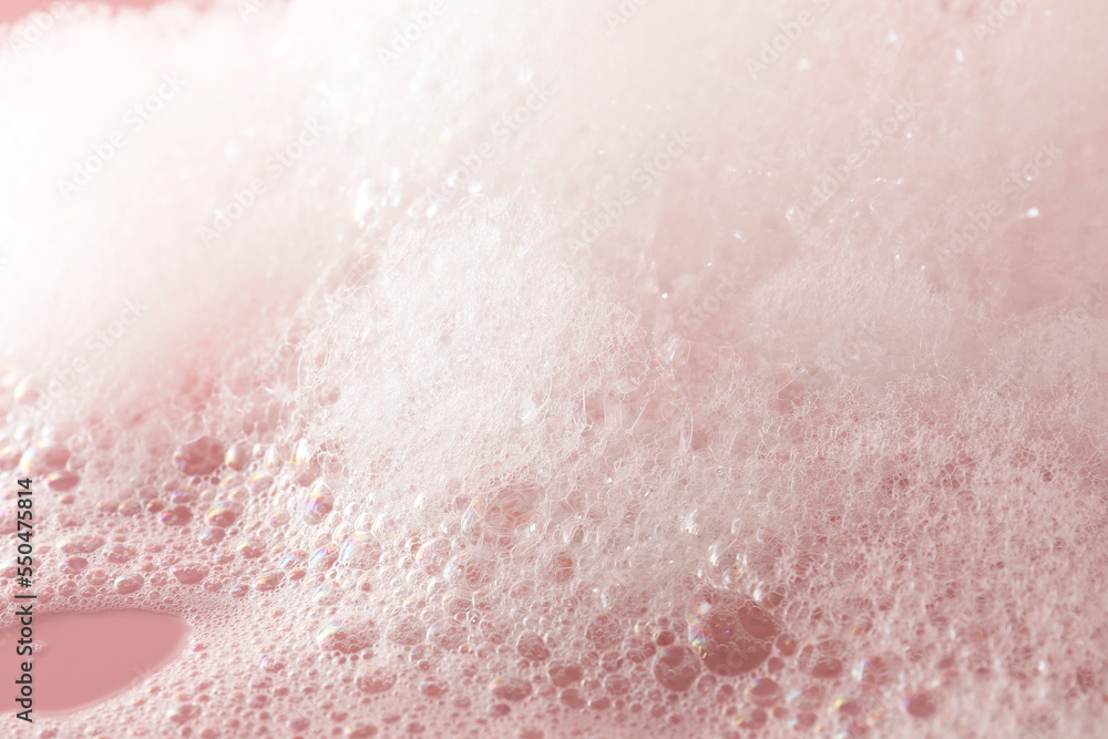 Fototapeta premium Fluffy bath foam on pink background, closeup