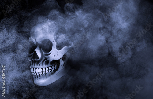 Scary skull emerging from smoke in darkness