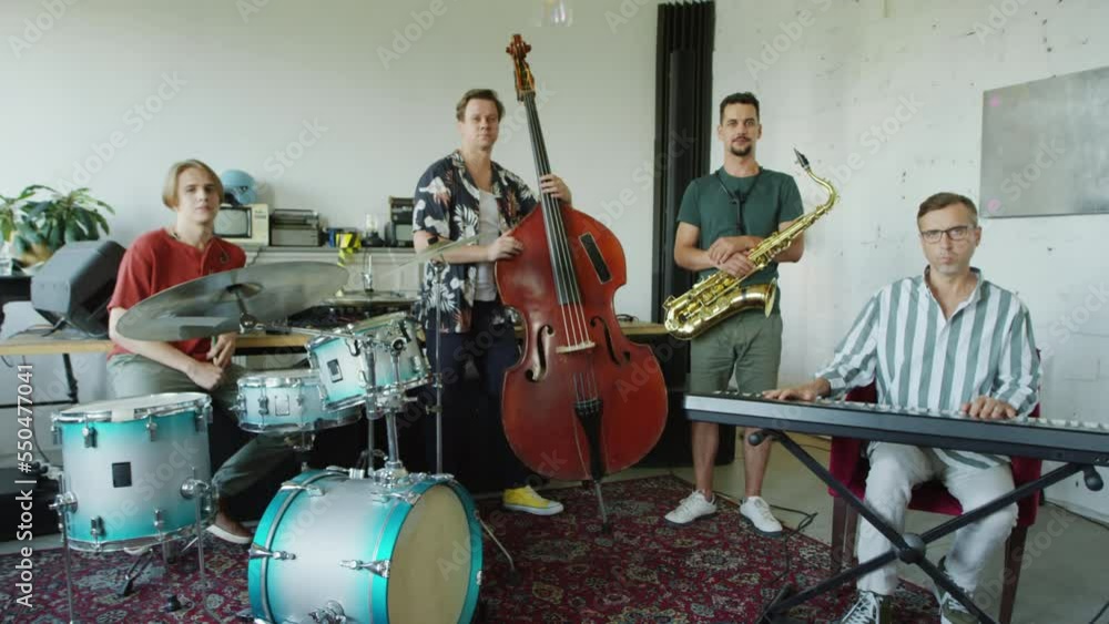 Zoom in group portrait shot of jazz band posing for camera with musical instruments in studio Zoom in group portrait shot of jazz band posing for camera with musical instruments in studio