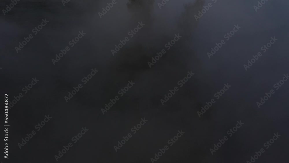 flying with drone next to a foggy lake over trees in foggy landscape flying with drone next to a foggy lake over trees in foggy landscape