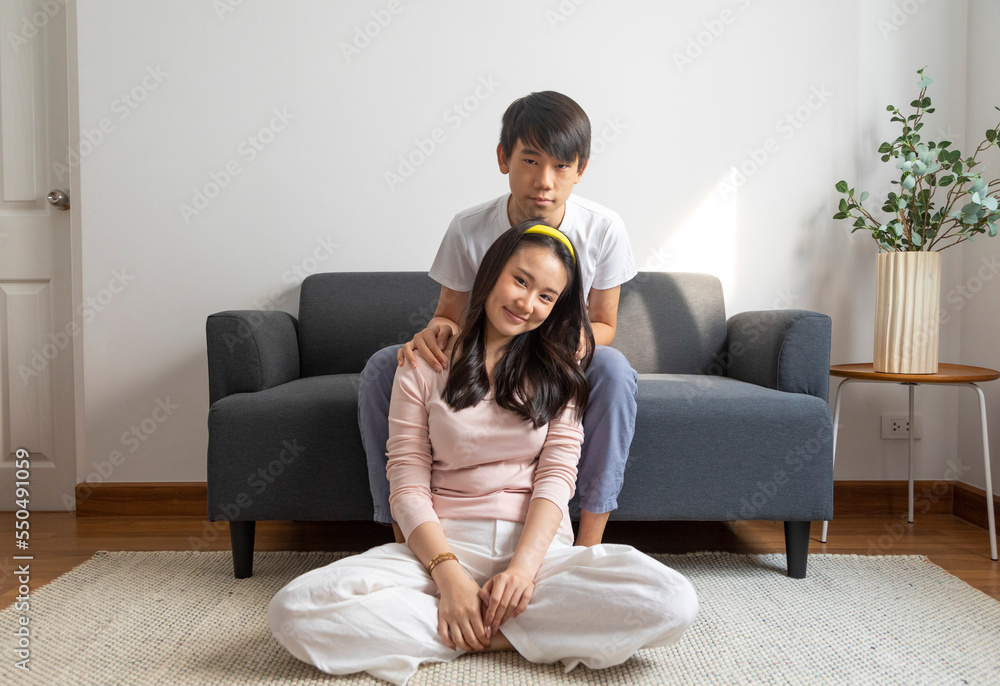 Asian brother and sister hugging with care and love sit on sofa at home. Asian brother and sister hugging with care and love sit on sofa at home.