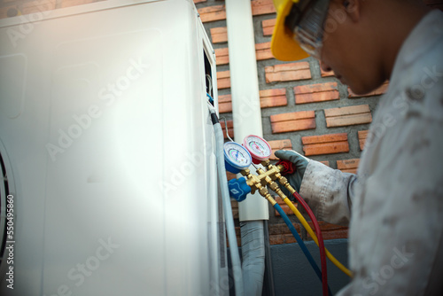 Technician is checking air conditioner ,measuring equipment for filling air conditioners..