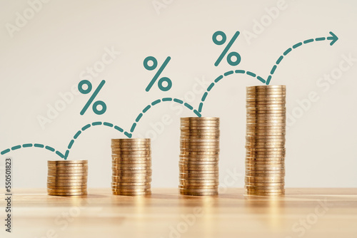 Rising stacked coins with percentage icon as a symbol of increasing living cost and expenses. Concept of inflation and economy affordability problems.