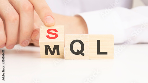 SQL or MQL symbol. Businessman turns cubes and changes words 'MQL marketing qualified lead' to 'SQL sales qualified lead'. Beautiful white background. photo