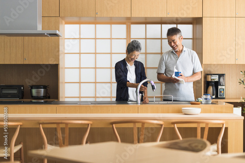 一緒にキッチンに立つ日本人シニア夫婦