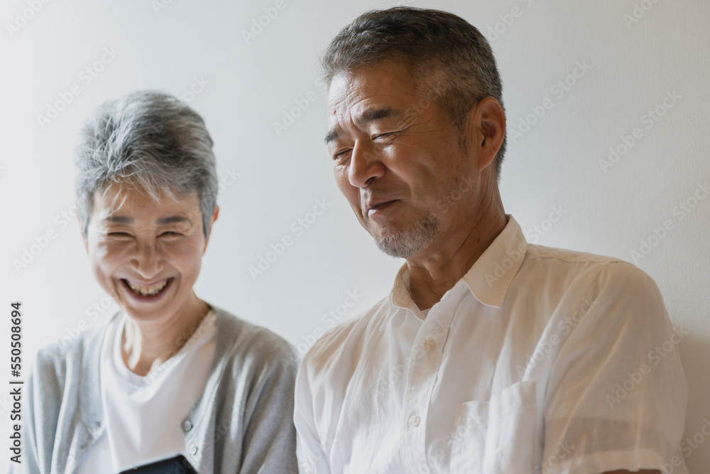 スマートフォンを見る日本人シニア夫婦 スマートフォンを見る日本人シニア夫婦