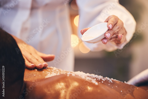 Massage, spa and scrub on a back for exfoliate treatment for soft, healthy and smooth skin. Luxury, wellness and therapist doing salt body exfoliation detox for health, hygiene and body care at salon