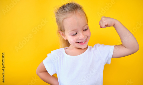 portrait Strong power preschool little girl flexing arm muscle smile isolated 