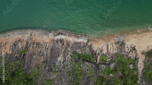 Aerial video of beach and ocean with drone flying down and spining around towards the beach