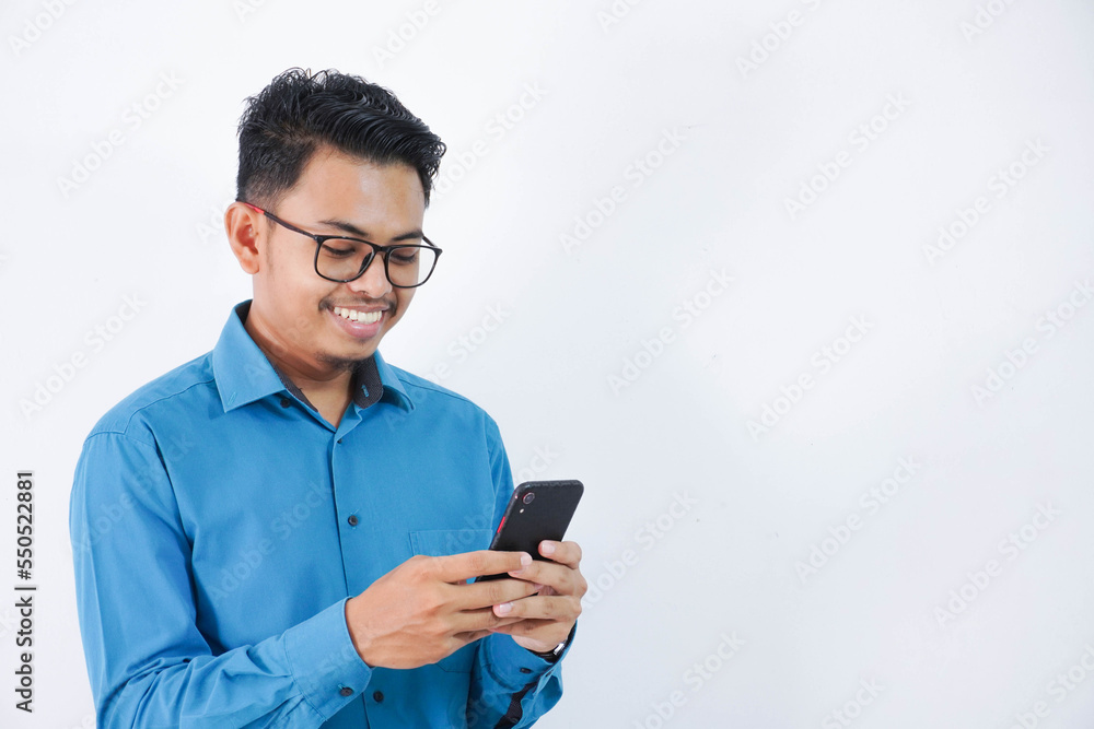 handsome smiling or happy Asian young employee man with glasses holding smart phone chatting on white isolated background. handsome smiling or happy Asian young employee man with glasses holding smart phone chatting on white isolated background.