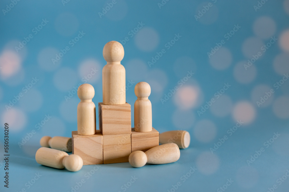 Concept of leadership, lead, inspire, empower, business, manager, teamwork, vision, strategy, influence, competition. Wooden doll or figure standing on wooden cube leading the team