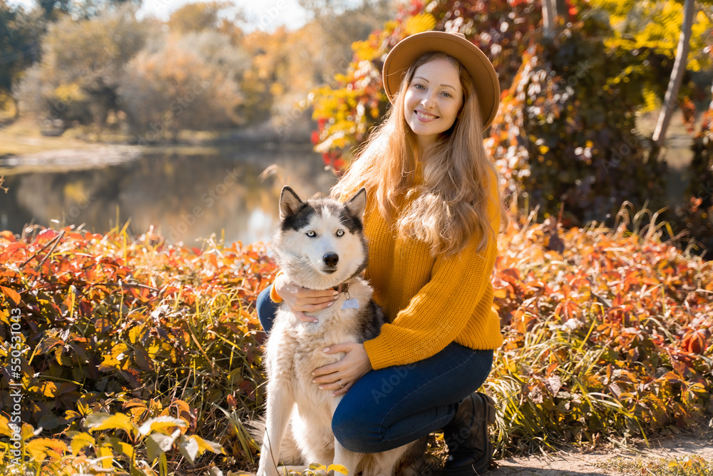 Girl with the husky in the autumn park
