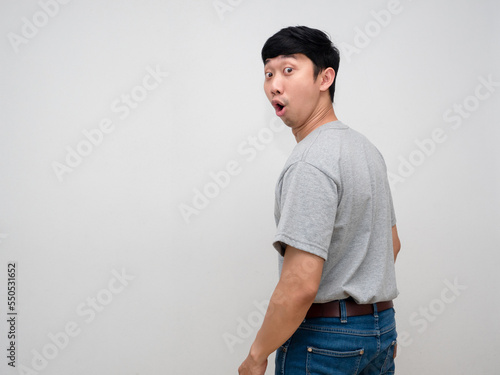 Fotografi Asian young man grey shirt feels amazed turn back to looking isolated