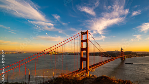 Golden Gate Bridge at sunset with boat entering San Francisco Bay