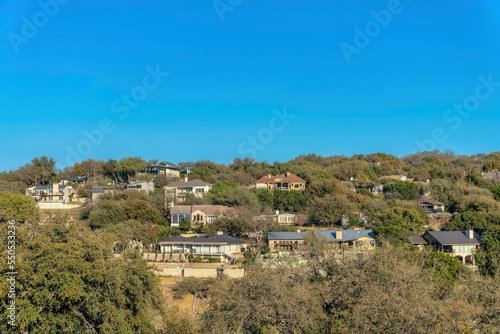 Austin, Texas- Facade of large house buildings surrounded by green trees near Lake Austin