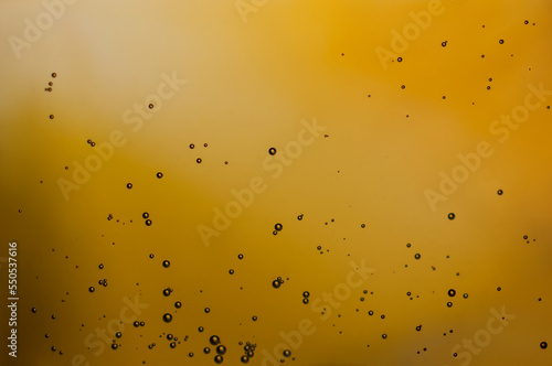 Macro photo of bubbles on yellow background.