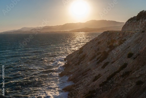 Turkey. Fethiye. View of Turkish Mediterranean coast at sunset. Emerald water washes rocky shore. Blurred background. Selective focus. Wild Mediterranean beach.