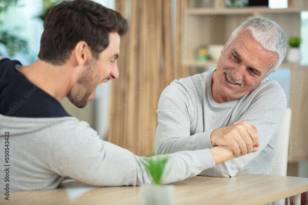 old father and his son are playing arm wrestle old father and his son are playing arm wrestle