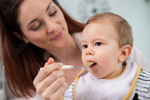 mother feeding baby with spoon