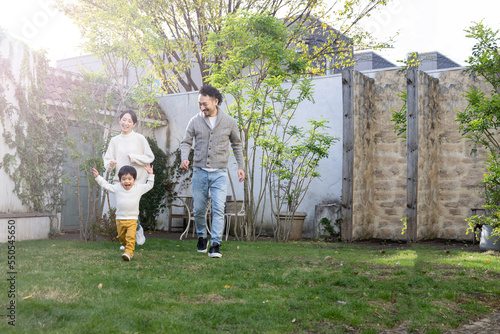 庭や公園で走り回る子どもと家族のイメージ 右にコピースぺースあり