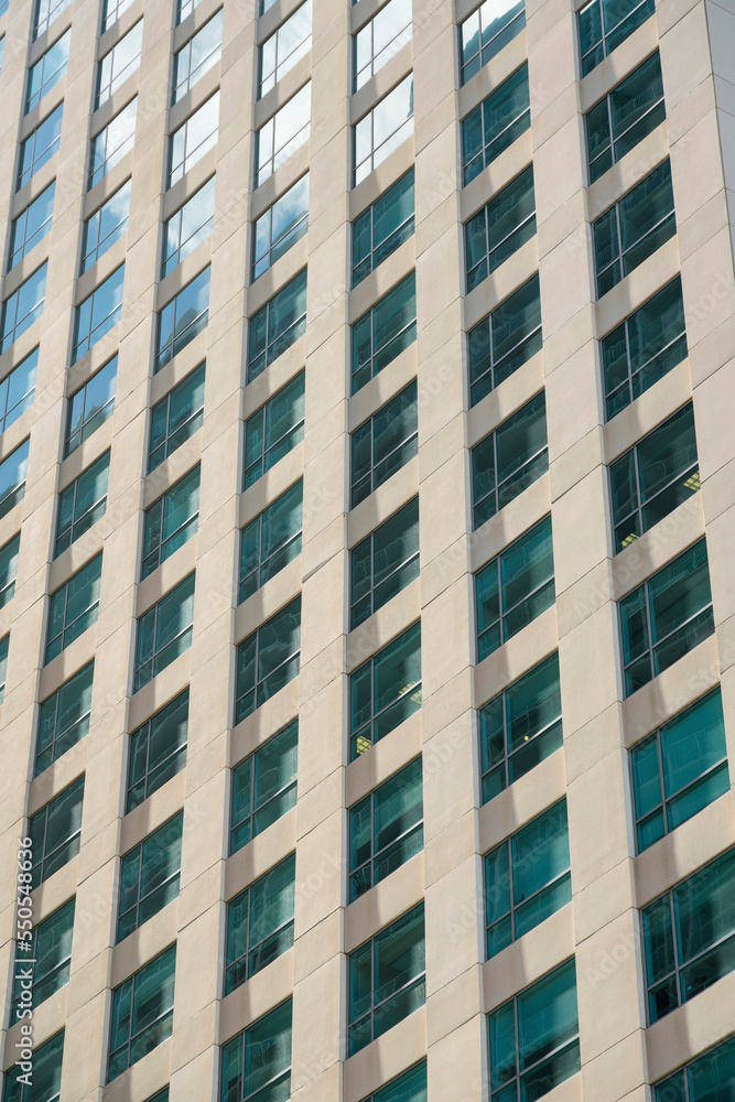 Grid multi-storey building close-up with clear reflective glass windows at Miami, Florida Grid multi-storey building close-up with clear reflective glass windows at Miami, Florida