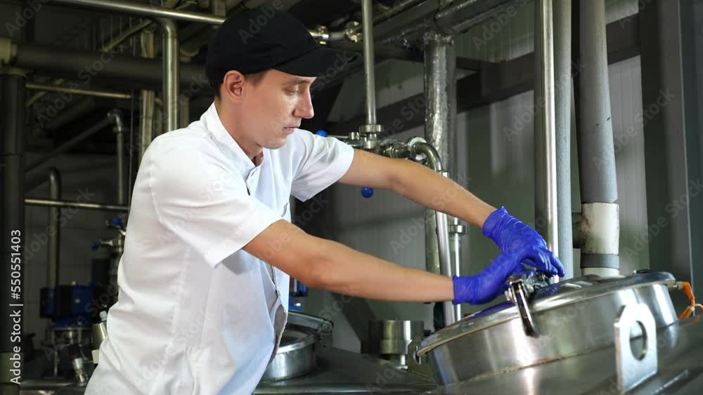 The process of producing various varieties of cheese on a dairy farm. A man in uniform shows the work of modern equipment. Dairy factory, cheese factory. The process of producing various varieties of cheese on a dairy farm. A man in uniform shows the work of modern equipment. Dairy factory, cheese factory.