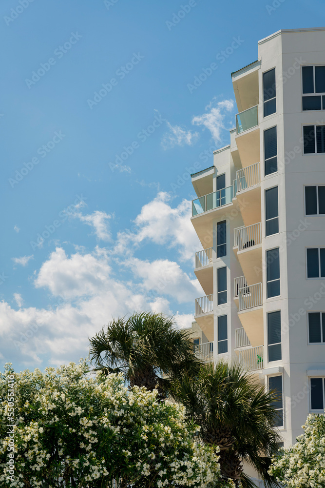 View of a building from below with balconies and tinted tall windows at Destin, Florida