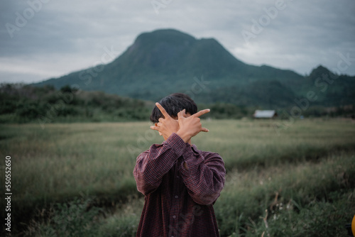 Wallpaper Mural man traveler with backpack holding hat and looking at amazing mountains and forest, wanderlust travel concept, space for text, atmospheric epic moment Torontodigital.ca