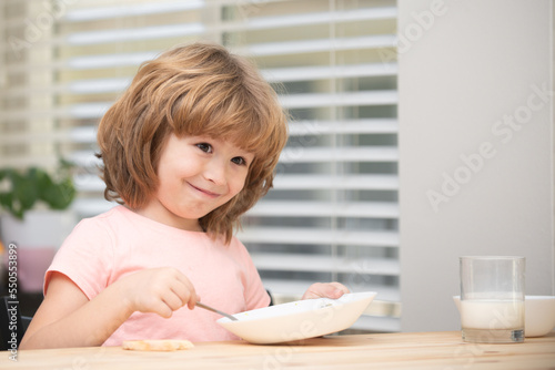 Child eating healthy food at home. Baby eat soup with spoon.
